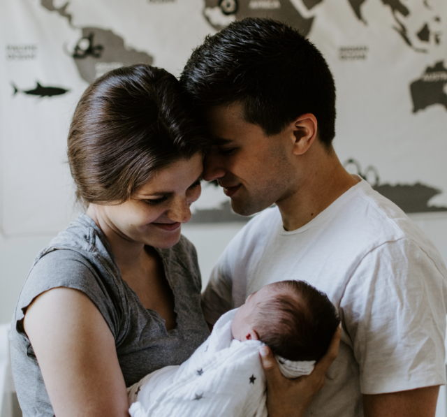 Mom and dad looking at baby lovingly.